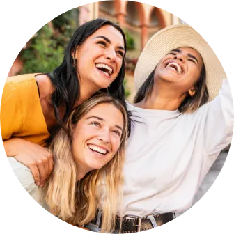 Trzy uśmiechnięte kobiety razem na świeżym powietrzu, letnia scena lifestyle.